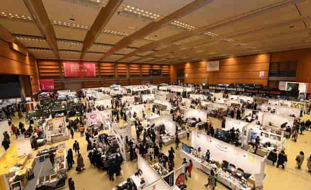 Bustling COEX Exhibition Hall C at a trade show with diverse booths and attendees.