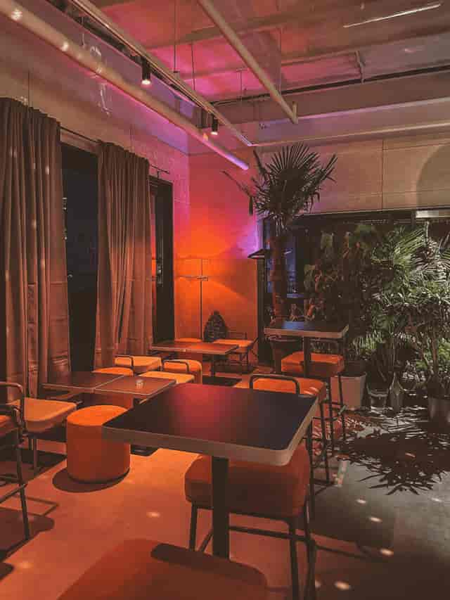 Stylish event space in SFACTORY with warm lighting and lush greenery for gatherings.