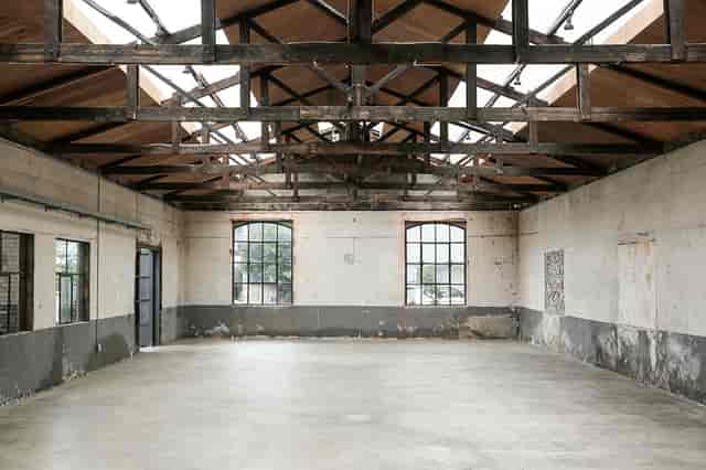 Spacious industrial venue with high ceilings for creative events and corporate gatherings.