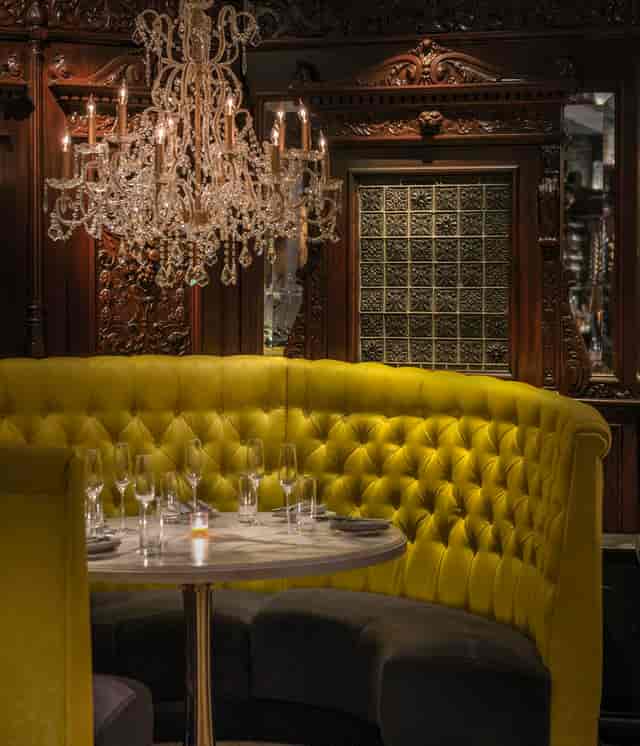 Elegant dining room at Yvonne's with plush yellow banquette for upscale events.