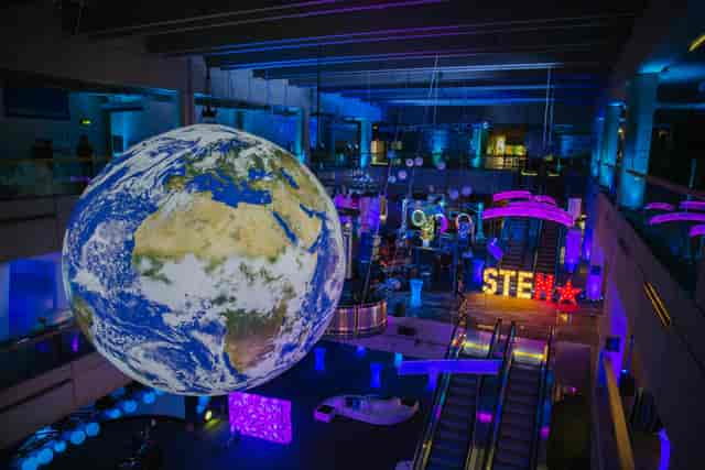 Vibrant event space with illuminated globe at Museum of Science for STEM networking events.