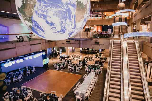 Spacious event venue with suspended globe, ideal for conferences and galas.