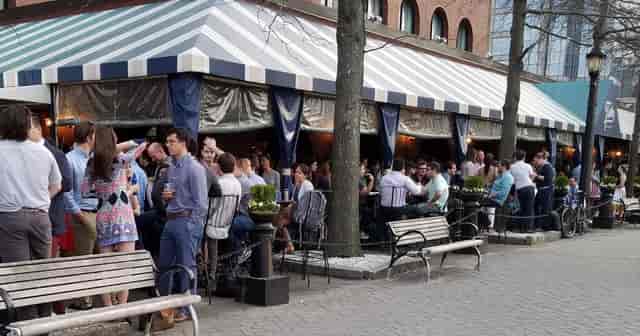 Waterfront patio in Tias with striped awning, perfect for networking events and receptions.
