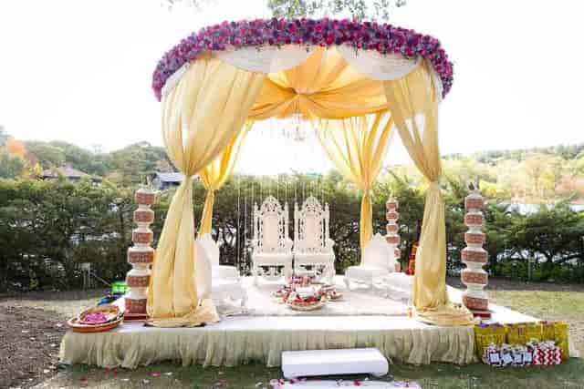 Elegant outdoor wedding venue at Boston Marriott Newton with floral canopy and ornate chairs.