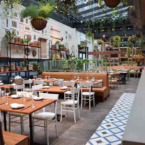 Modern dining space in Eataly Boston, perfect for events with flexible seating and greenery.