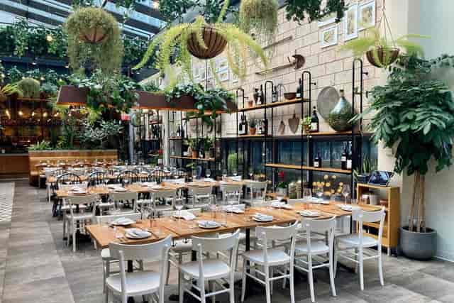 Elegant dining space in Eataly Boston, ideal for events with lush greenery and warm lighting.