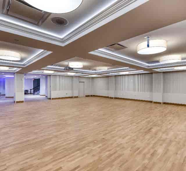 Versatile event space at The Schuyler in Hamilton Hotel with modern lighting and wooden floor.
