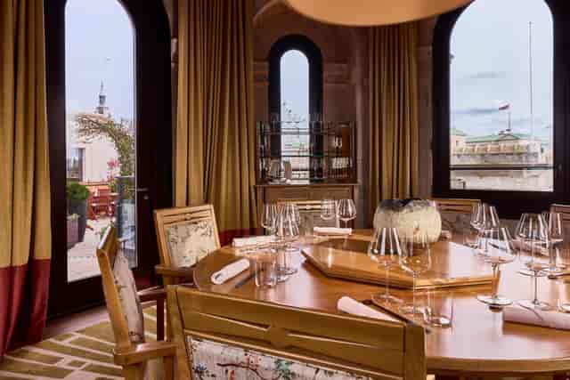 Elegant meeting space with wooden table, fine glassware for exclusive dining events.