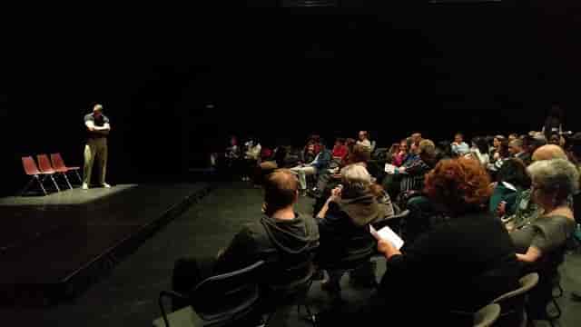 Black Box Theatre event in Anacostia with engaged audience and speaker on stage.