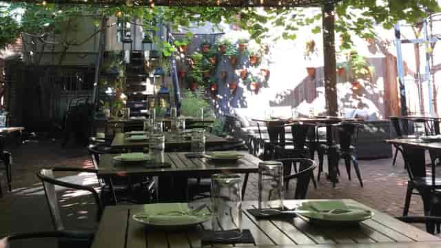 Charming garden patio with lush greenery, ideal for outdoor dining events and gatherings.