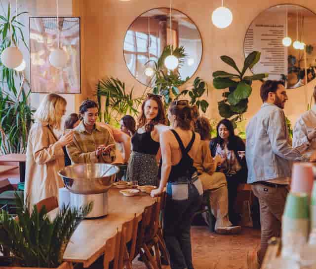Vibrant networking event in stylish coworking space with lush greenery and modern decor.