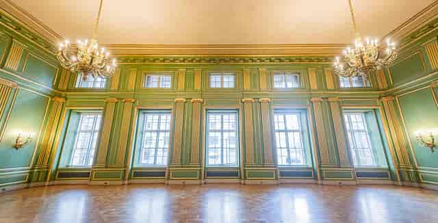 Elegant Green & Gold Room with high ceilings, perfect for upscale events and meetings.