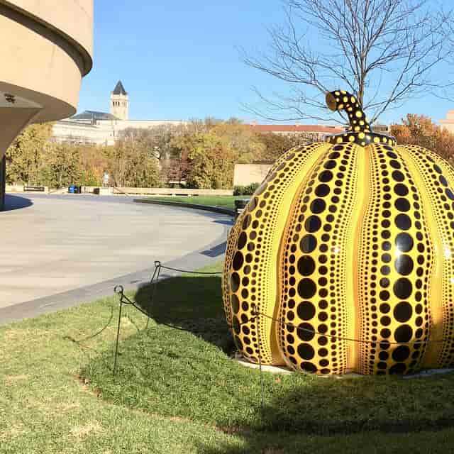 Large yellow and black polka dot pumpkin sculpture at Hirshhorn Museum for outdoor events.