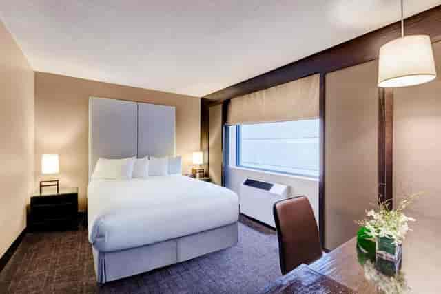 Modern hotel suite in Ottawa with a comfortable bed, perfect for event attendees.