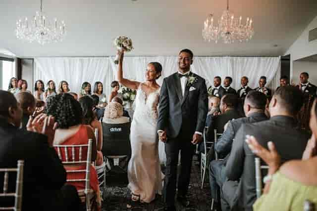 Joyful wedding ceremony in elegant Top of the Town ballroom with chandeliers.