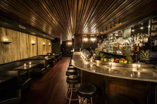 Stylish cocktail bar with dark wood accents, perfect for receptions and private parties.