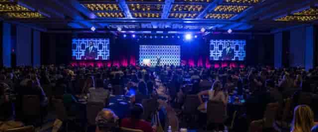 Grand Ballroom Office event with speaker, engaged audience, networking atmosphere.