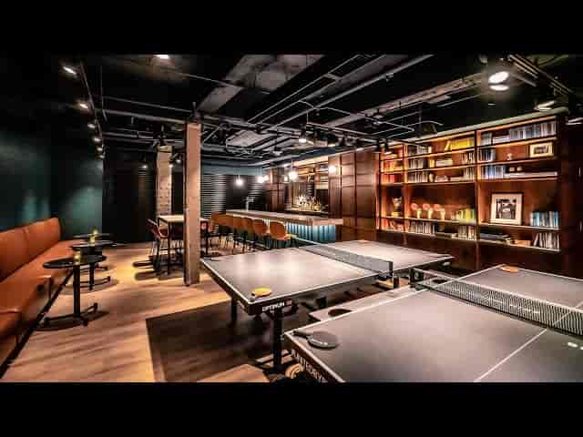 Stylish multifunctional event space with ping pong tables for corporate gatherings.
