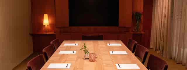 Iris in Miss Clara meeting room with sleek wooden table, ideal for professional events.