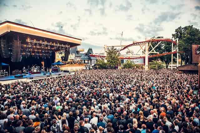 Vibrant outdoor concert at Gröna Lund with enthusiastic crowd and illuminated stage.