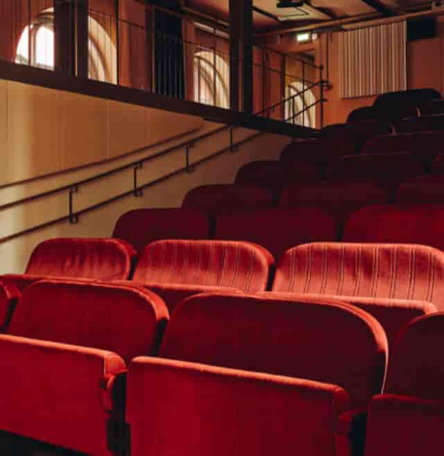 Cinema auditorium with plush red seating, ideal for presentations and performances.