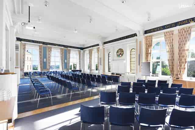 Bright meeting room with blue chairs for events at Ersta Conference, perfect for workshops.