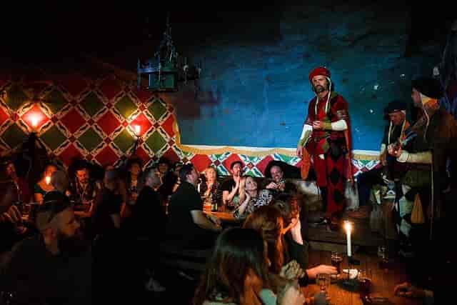 "Vibrant medieval restaurant with performers engaging guests in a themed event setting."