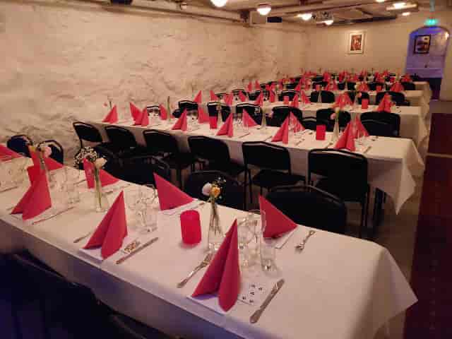 Elegant banquet setup with white linens and red napkins for corporate events.
