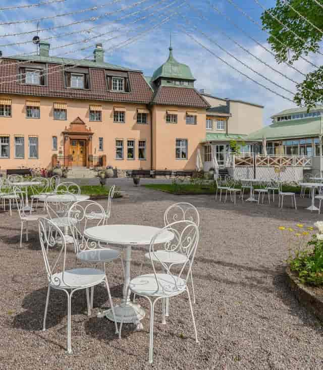 Outdoor restaurant venue with white wrought-iron furniture for events and meetings.