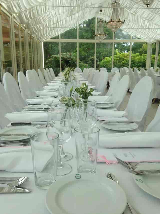 Elegant dining setup with floral centerpieces at Rosendals Wärdshus event.