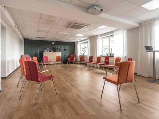 Banquet hall at Hotel Kristina with colorful chairs for workshops and meetings.
