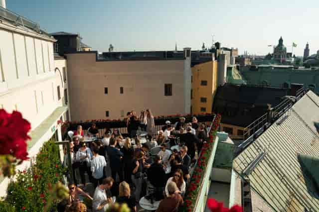 Vibrant rooftop event at Le Hibou, featuring lush florals and city views for networking.