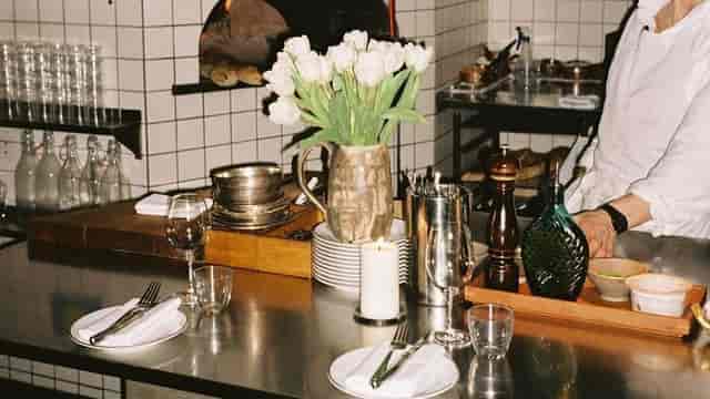 Elegant chef's table setup with tulips for upscale dining event in India.