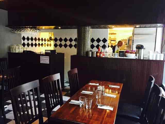 Cozy restaurant dining space with polished wooden table, ideal for networking lunches.