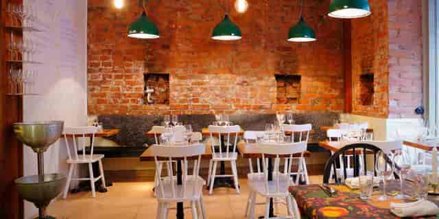 Cozy restaurant with exposed brick walls, perfect for intimate gatherings and meetings.