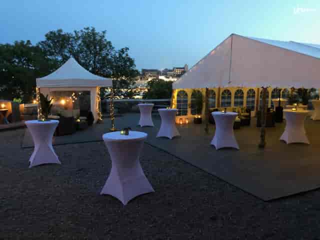 Elegant outdoor banquet hall with high-top tables, perfect for evening events and gatherings.