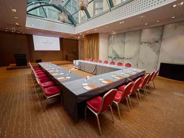 Conference venue with U-shaped table setup for corporate events and presentations.