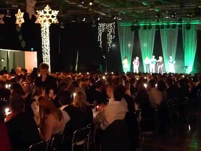 Live music gala at Magasin 9 with elegant candlelit tables and vibrant green stage lighting.