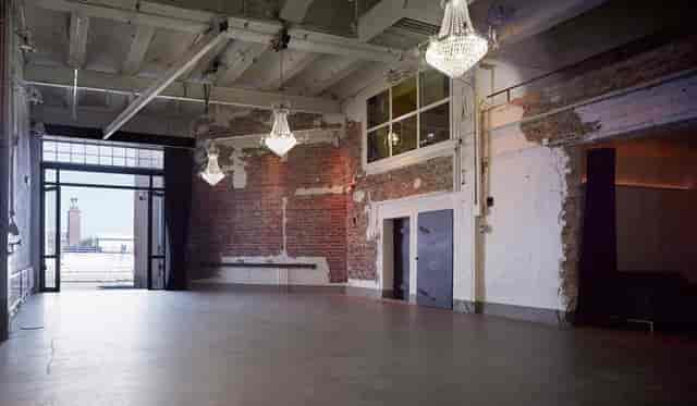 Spacious industrial venue with exposed brick for corporate events and gatherings.