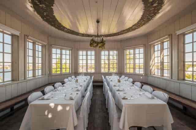 Elegant banquet hall in Fåfängan with long tables, ideal for meetings and celebrations.