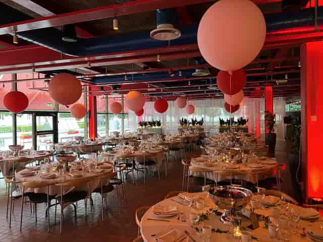 Elegant event space at Patisserie Garnisonen with fine dining setup and festive balloons.