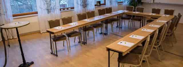 Conference center meeting room with long tables, ideal for workshops and strategy sessions.
