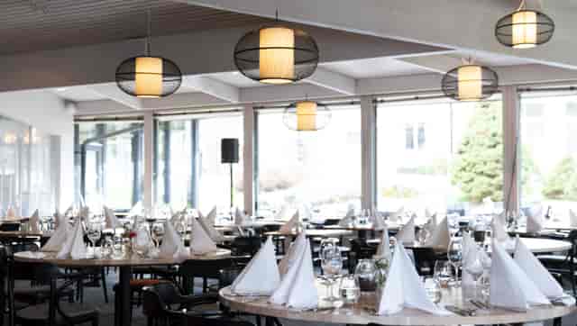 Elegant conference room with set tables, ideal for meetings and events.