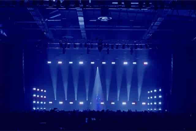 Annexet event space with blue-lit stage for dynamic presentations and performances.