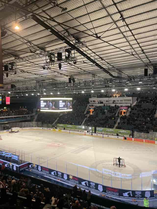 Hovet arena set for hockey game with high ceilings and large audience.