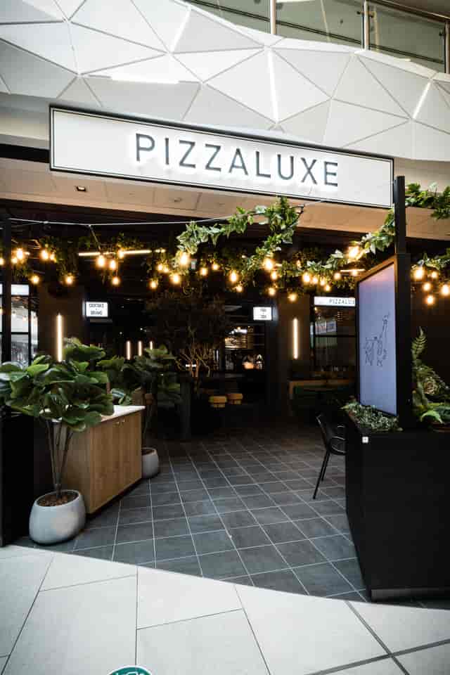 Stylish event space at PizzaLuxe Manchester with greenery, ideal for networking and gatherings.