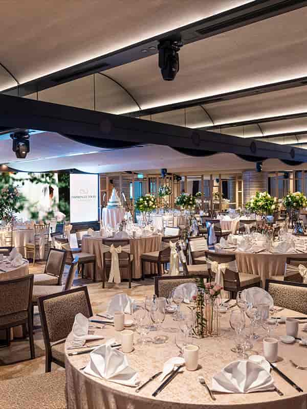 Atrium Ballroom at PARKROYAL: elegant wedding venue with floral centerpieces and soft lighting.