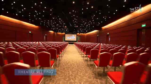 Multi-purpose event hall with red chairs, ideal for conferences and presentations.