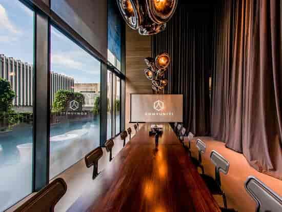 Modern meeting room in YOTEL Singapore with wooden table, ideal for corporate events.