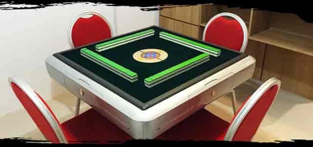 Modern mahjong table with red chairs for engaging events and networking activities.